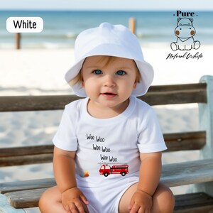 a baby sitting on a bench wearing a white hat
