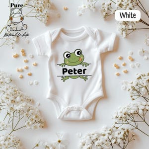 a white bodysuit with a green frog on it