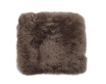 May include: A brown faux fur throw pillow with a soft, fluffy texture.