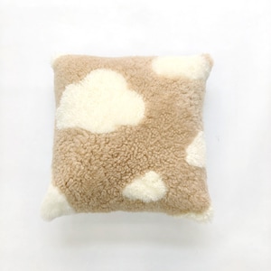 May include: A square decorative pillow with a beige, textured surface and white cloud-shaped accents. The pillow has a fluffy, soft appearance, and the clouds are evenly spaced across the surface. The pillow is designed for home decor.
