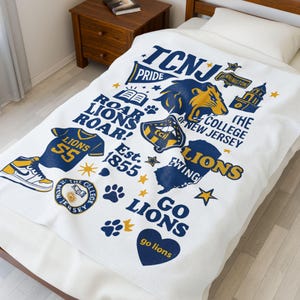 May include: White blanket featuring a navy blue and gold design with the text "TCNJ Pride", "The College of New Jersey", and "Go Lions". The blanket includes a lion graphic, a jersey, and a sneaker.