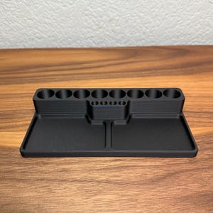 May include: Black plastic organizer with 10 round compartments and two rectangular trays.