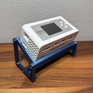 May include: A white 3D printer with a blue metal stand. The printer has a small LCD screen and the text "Gens ACC" and "MARS D300" printed on it.