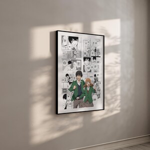 Op de afbeelding: Een ingelijste manga-kunstprint met een zwart-wit stripverhaal met een stel in het midden. Het stel draagt groene jassen en bruine broeken. De print zit in een zwart frame en hangt aan een witte muur.