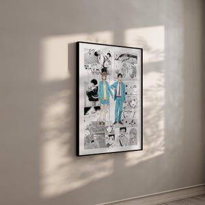 May include: A black framed print displaying a manga-style illustration. The artwork shows a couple holding hands, set against a backdrop of manga panels. The colour scheme is predominantly black, white, and grey, with accents of blue and yellow.
