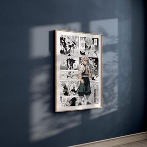 May include: A framed manga art print, depicting a character in a white jacket and dark green trousers. The black and white artwork includes speech bubbles and panels. The frame is gold-coloured, and the print is displayed on a dark blue wall.