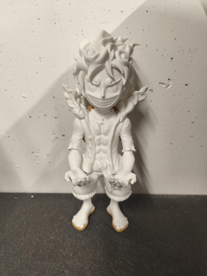 May include: A white, unpainted 3D printed figurine of a character with spiky hair, a wide grin, and an open-chested vest. The figure stands in a dynamic pose with arms extended forward, featuring detailed facial expressions and textured hair.