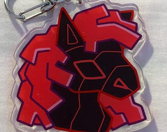 Op de afbeelding: Een heldere acryl sleutelhanger met een geometrisch ontwerp van een wolvenkop. Het ontwerp is voornamelijk zwart en rood met paarse contouren. De sleutelhanger heeft een zilveren metalen sluiting en ring.