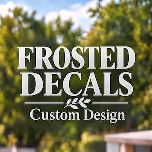 May include: A frosted decal applied to a transparent surface featuring the white text FROSTED DECALS in a bold serif font, a small leaf graphic centered below, and the text Custom Design in a smaller serif font underneath.