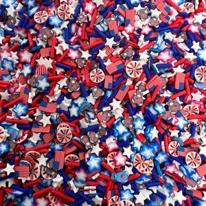 May include: A collection of red, white, and blue sprinkles with various shapes, including stars, stripes, and swirls. The sprinkles are perfect for decorating cakes, cupcakes, and other desserts.