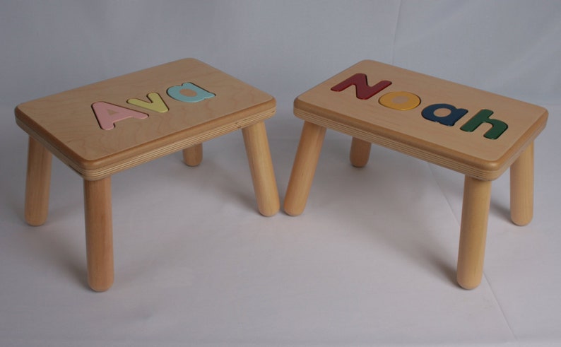 May include: Two wooden children's step stools with the names "Ava" and "Noah" spelled out in colorful letters on the top.