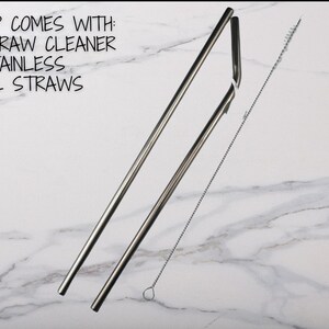 May include: Two silver metal straws and a silver straw cleaning brush on a white marble surface.  The text "EACH CUP COMES WITH: 1 STRAW CLEANER 2 STAINLESS STEEL STRAWS" is visible in the top left corner of the image.