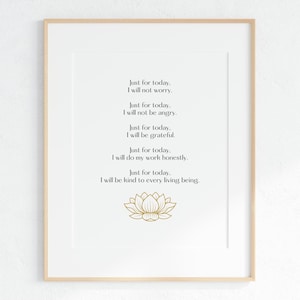 以下が含まれることがあります： 白い背景に「今日だけ。心配しません。」などの肯定的な言葉が黒字で書かれたフレーム入りプリント。下部には金の蓮の花があります。フレームは明るい木の色です。