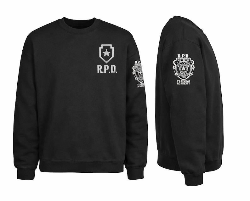 May include: Black crewneck sweatshirt with white graphics. The front features "R.P.D." and a star emblem. The sleeve displays a badge with text "R.P.D. OFFICER TRAINING ACADEMY". The sweatshirt is shown from the front and side.