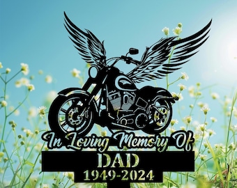May include: Black metal memorial garden stake featuring a motorcycle with wings. The stake has the text "In Loving Memory Of DAD 1949-2024".