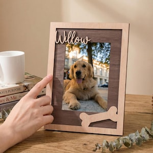 Op de afbeelding: Een rechthoekige houten fotolijst met een lichte houten buitenrand en een donker houten binnenpaneel. De lijst is voorzien van de naam Willow in schrijfletters aan de bovenkant en een botvormige uitsparing rechtsonder.