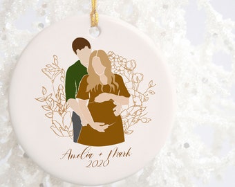 May include: A white porcelain ornament with a gold outline of a couple, a woman with long blonde hair and a man with short brown hair, standing together. The woman is pregnant and holding her belly. The ornament has a gold floral design and the text "Amelia + Mark 2020".