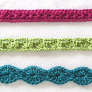 May include: Three crochet trim samples in different colors and patterns. The top trim is a deep pink with a simple stitch pattern. The middle trim is a bright green with a more intricate stitch pattern. The bottom trim is a teal blue with a wavy stitch pattern.