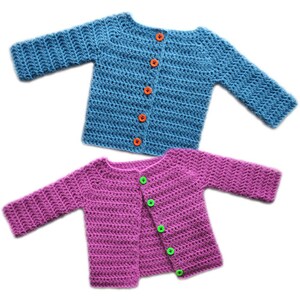 Könnte beinhalten: Zwei gehäkelte Baby-Cardigans, einer blau mit orangefarbenen Knöpfen und einer rosa mit grünen Knöpfen.