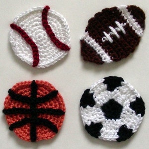 May include: Four crocheted sports balls: a baseball with red stitching, a football with white laces, a basketball with black lines, and a soccer ball with black pentagons.