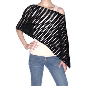 May include: Black crochet poncho with a diagonal striped pattern. The poncho is worn over a white tank top and blue jeans.