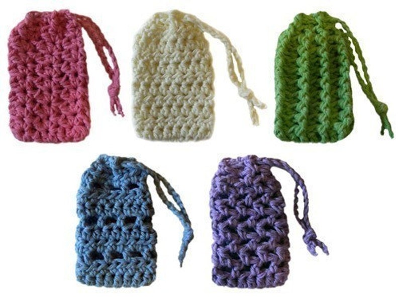 May include: Set of six crocheted soap sacks in various colours, including pink, white, green, blue, and purple. Each sack has a drawstring closure.