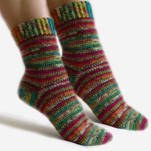May include: A pair of colorful striped crochet socks. The socks are made with a variety of colors, including red, orange, yellow, green, blue, and purple.