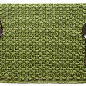 Puede incluir: Un mantel individual de crochet verde con un tenedor y una cuchara encima.