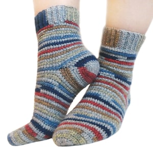 May include: A pair of striped crochet socks in shades of blue, brown, red, and gray. The socks are ankle-high and have a ribbed cuff.