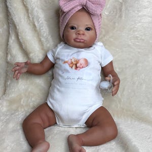 Bambina Reborn etnica, in vinile con corpo in tessuto