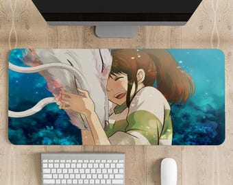 May include: A white and blue anime-style desk mat featuring a girl with brown hair hugging a white dragon-like creature. The background is a blue and green ocean scene.