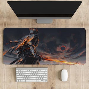Könnte beinhalten: Eine schwarze und orangefarbene Gaming-Mausmatte mit einer dunklen Fantasy-Illustration eines Ritters mit einem flammenden Schwert, der vor einem dunklen, wirbelnden Himmel mit einer roten Sonne steht.