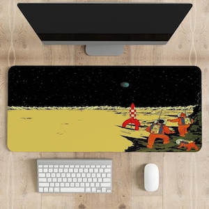 Puede incluir: Una alfombrilla de escritorio amarilla y negra con una ilustración de dibujos animados de astronautas en la luna. Los astronautas están de pie cerca de un cohete rojo y blanco. El fondo es un cielo negro con estrellas y un planeta azul.