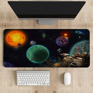 Pode incluir: Um tapete de rato preto e branco com tema espacial com um grande planeta verde, um sol e uma nave espacial. O tapete de rato está sobre uma superfície de madeira com um teclado e um rato branco.
