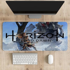 May include: A blue and white gaming mouse pad with a graphic of a woman holding a bow and arrow, a large mechanical creature, and the text "Horizon Zero Dawn".