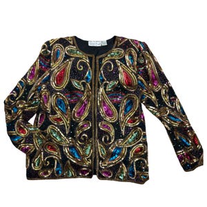 May include: Black jacket with colorful sequin paisley design. The jacket features a round neckline and long sleeves. The paisley design includes gold, red, blue, purple, and green sequins. The jacket is fully covered in sequins.