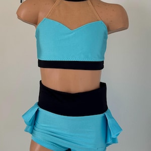 May include: A turquoise dance costume with a black halter top and a matching skirt. The top has a sheer mesh panel and the skirt has a ruffled hem.