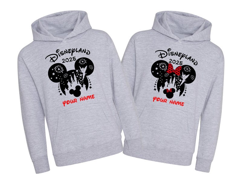 Może przedstawiać: Dwie szare bluzy z kapturem z czarno-białym nadrukiem głowy Myszki Miki z tekstem "Disneyland 2025" i "Your Name" nadrukowanym z przodu.
