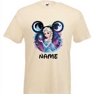 May include: A cream-colored t-shirt featuring a graphic of a princess with a blue dress, surrounded by a starry background and two moon-shaped designs. The word "NAME" is printed in black below the graphic.