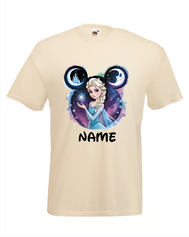 May include: A cream-colored t-shirt featuring a graphic of a princess with a blue dress, surrounded by a starry background and two moon-shaped designs. The word "NAME" is printed in black below the graphic.