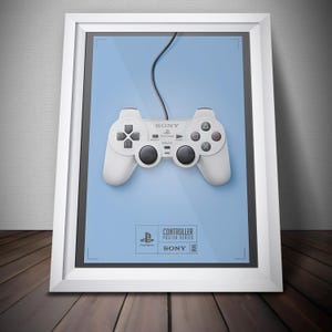 May include: Framed poster featuring a white PlayStation controller against a light blue background. The controller has black buttons and a black cable. The poster includes the Sony and PlayStation logos, and the text "Controller Poster Series".