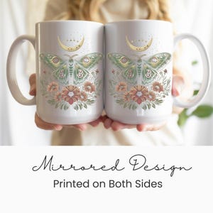 May include: Two white ceramic mugs with a mirrored design. Each mug features a green and gold moth illustration with floral accents and a crescent moon. The text "Mirrored Design Printed on Both Sides" is below the mugs.