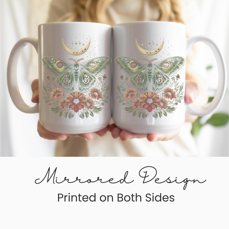 May include: Two white ceramic mugs with a mirrored design. Each mug features a green and gold moth illustration with floral accents and a crescent moon. The text "Mirrored Design Printed on Both Sides" is below the mugs.
