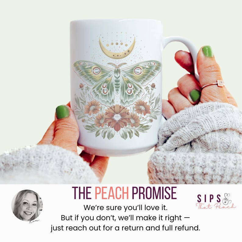 May include: White ceramic mug featuring a green and gold moth design with a crescent moon and floral accents. The mug has a large handle and is held by a person. The text "THE PEACH PROMISE" is visible.