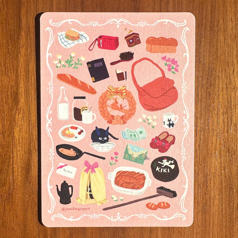 Pu&ograve; includere: Una carta rosa illustrata con un bordo decorativo, raffigurante vari oggetti, tra cui cibo, una borsa rossa, un gatto nero e una ghirlanda. La carta include il testo "@jennifergangart".