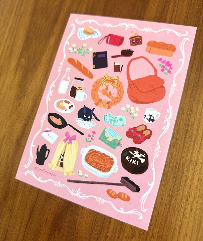 Pu&ograve; includere: Una stampa rosa con illustrazioni di un gatto nero, una borsa, pane e una torta con la parola "KIKI". La stampa ha un bordo decorativo bianco e la firma dell'artista.