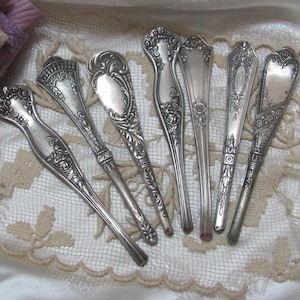 May include: A set of seven antique silver-plated serving spoons with ornate designs. The spoons have a vintage look and are perfect for adding a touch of elegance to any table setting.