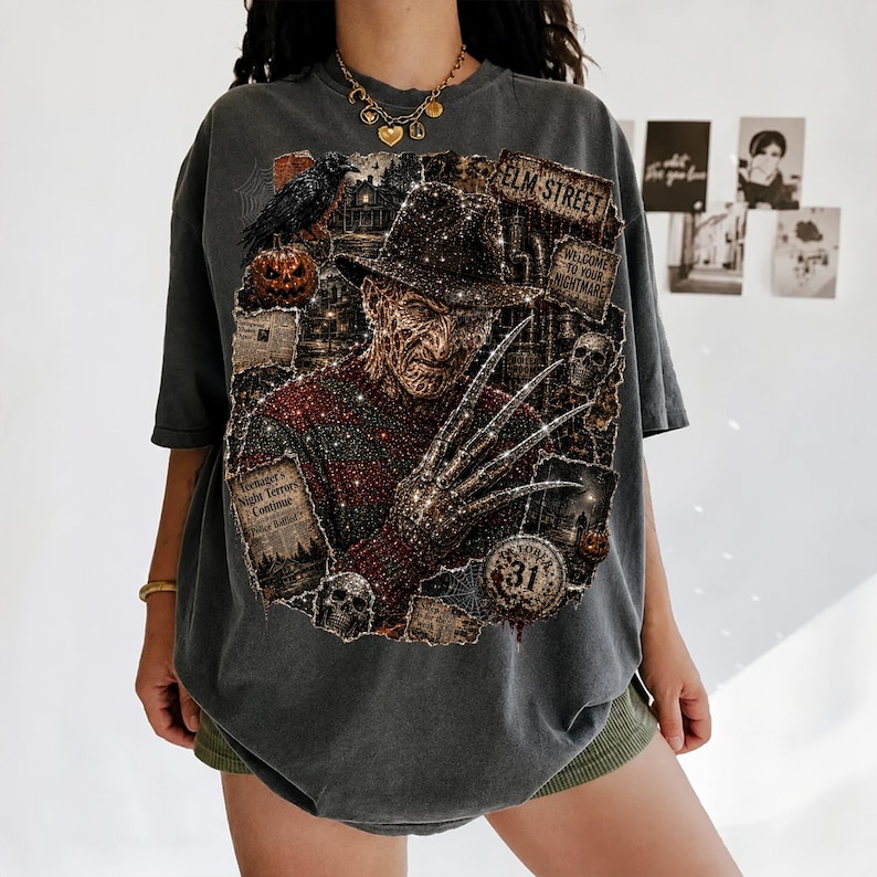 May include: A charcoal gray oversized t-shirt featuring a graphic print of a character with a fedora, a red and green striped sweater, and bladed fingers. The design includes text reading Elm Street, Welcome to your nightmare, and 31.