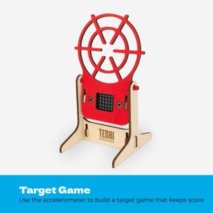 May include: A red wooden target game structure with a circular top and a base featuring the text TECHI EDUCATION. The device includes a central electronic component with a grid display and two buttons, mounted on a light-coloured wooden stand.