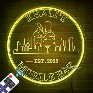 Może przedstawiać: Neonowy znak z napisem "KHALI'S MOBILE BAR" w okrągłym kształcie. Znak przedstawia ilustrację barmana, panoramę miasta i rok "EST. 2025". Pilot znajduje się w lewym dolnym rogu.